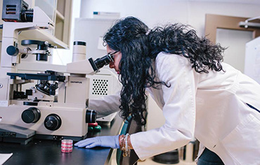 Photo of a female student using a microscope