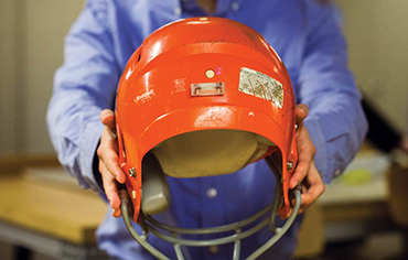 Photo of person holding a football helmet