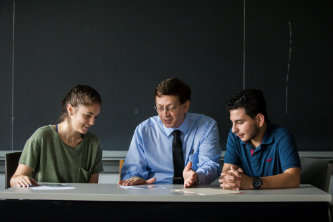 Associate professor of physics Jerome Licini (center) shows Florencia Dayan '21 (left) and George Awad '22 (right) how to use his tilted-axes tool.