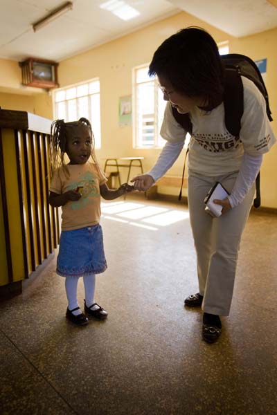 Xuanhong Cheng talks with a young girl during her visit to the Karuri Health Centre in Kenya