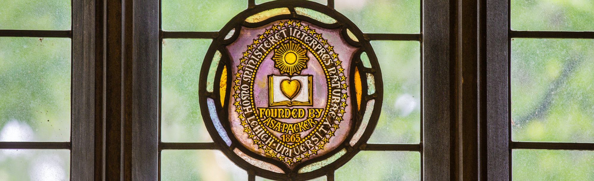 Close up of stained glass window containing the Lehigh shield and motto
